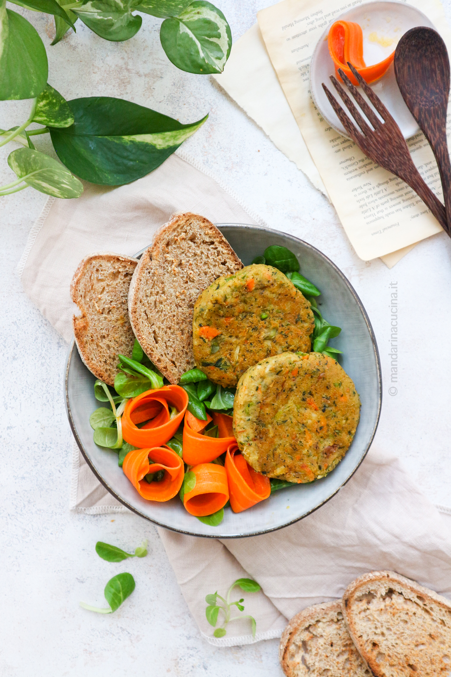 Nella foto i burger di minestrone su un piatto di insalata con fette di pane a decorare